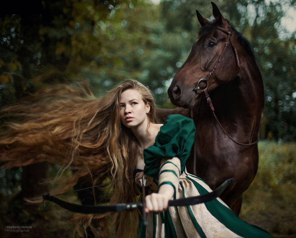 Обои для рабочего стола Модель Натали с луком в руке стоит рядом с лошадью, by Marketa Novak / Маркета Новак