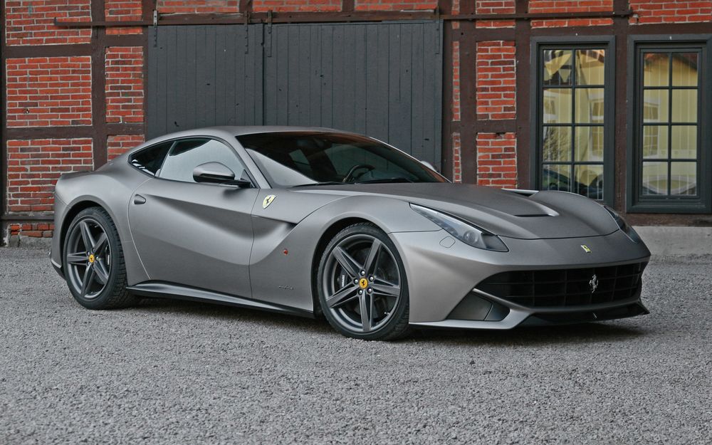 Обои для рабочего стола Матово-серый Ferrari F12 у кирпичного дома