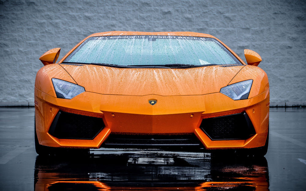 Обои для рабочего стола Ярко-оранжевый Lamborghini Aventador покрытый каплями дождя