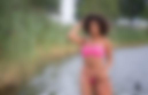 Обои на рабочий стол Девушка в купальнике позирует у воды