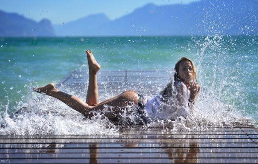 Обои на рабочий стол Девушка лежит на мостках в брызгах морской воды, фотограф Giovanni Zacche