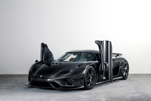Обои на рабочий стол Koenigsegg Regera в карбоне стоит на белом фоне с открытыми дверьми