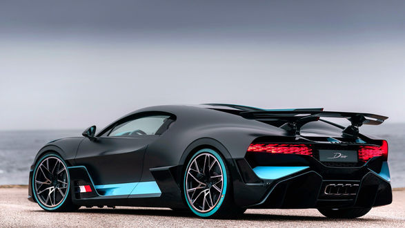 Обои на рабочий стол Французский гиперкар Bugatti Divo стоит на песке на фоне моря