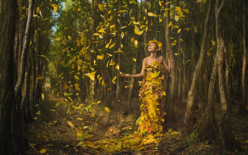 Обои для рабочего стола Девушка в венке из осенних листьев и вся покрытая ими стоит у дерева под листопадом, фотограф Иван Славов