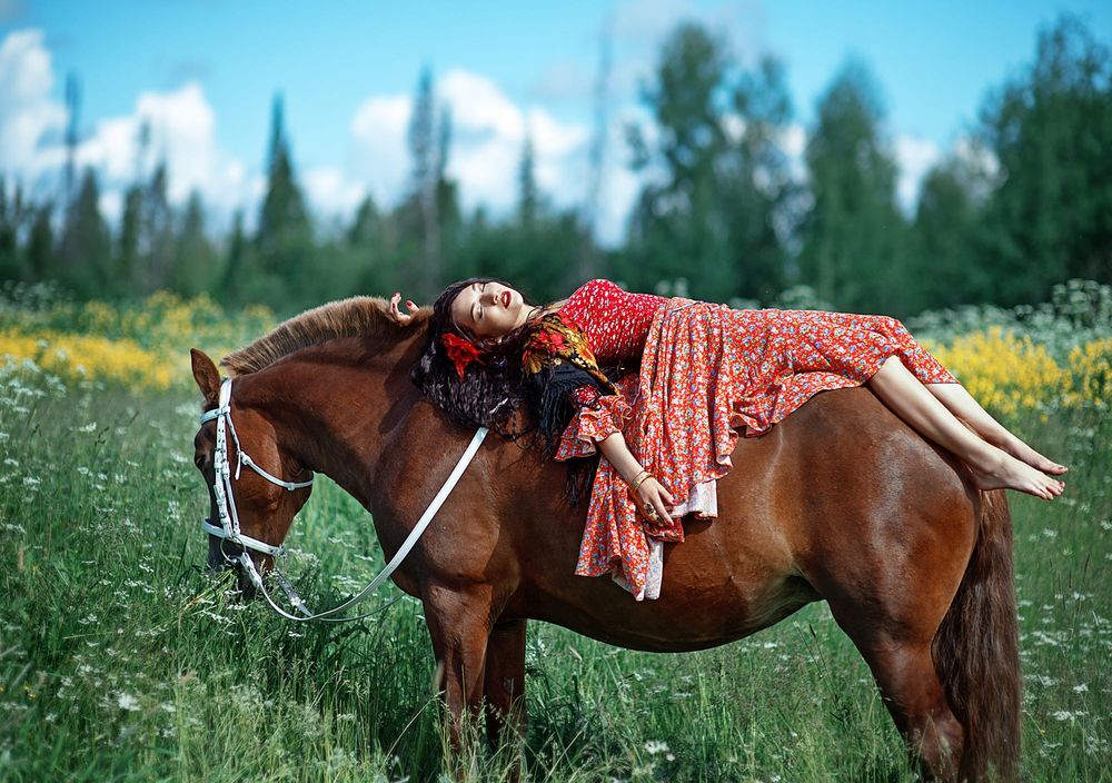 Обои для рабочего стола Девушка лежит на коне на лугу