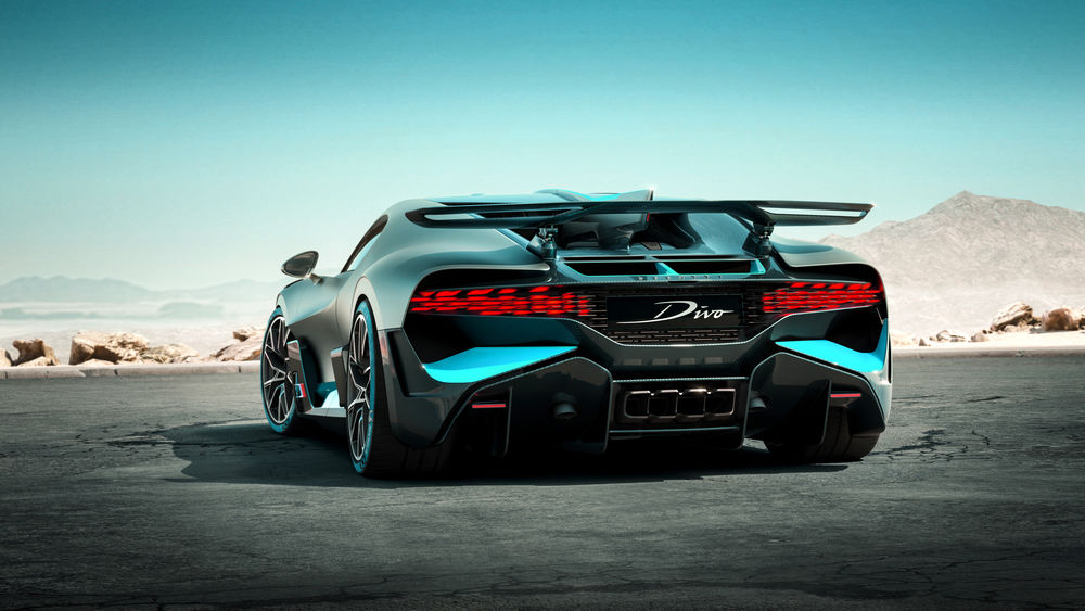Обои для рабочего стола Французский гиперкар Bugatti Divo стоит на треке на фоне гористой местности