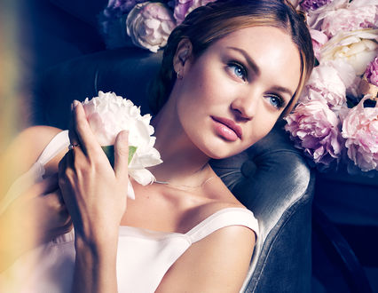 Обои на рабочий стол Модель Candice Swanepoel / Кэндис Свэйнпол с белым цветком пиона в руках сидит на кресле