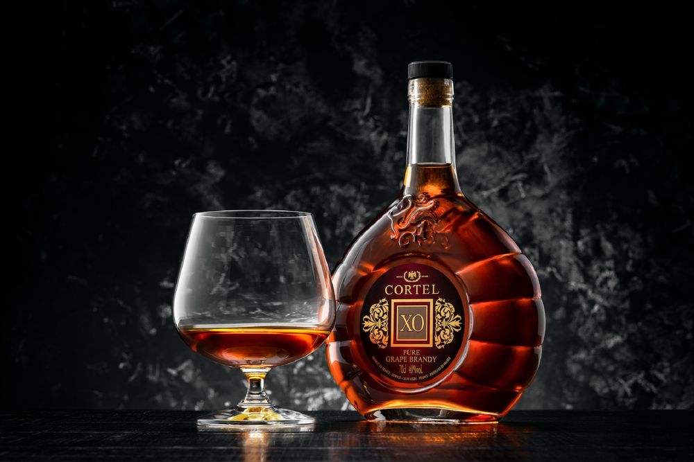 Обои для рабочего стола Бутылка бренди Hennessy XO с бокалом на темном фоне, фотограф Серкин Антон