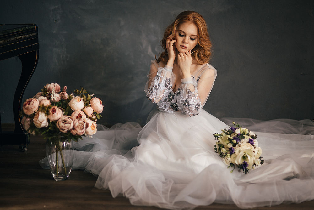 Обои для рабочего стола Девушка в свадебном платье сидит на полу с букетом цветов на платье, фотограф Sergey Vostrikov