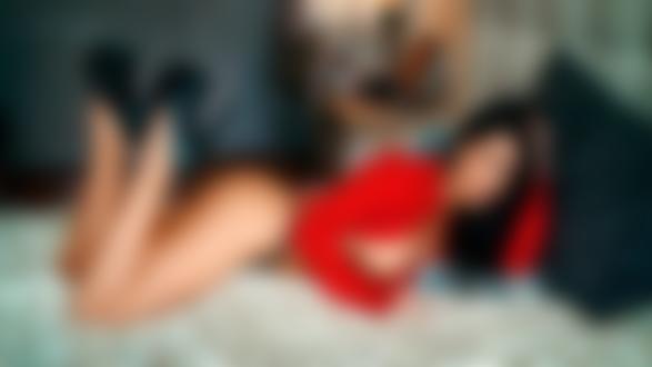 Обои для рабочего стола Полуобнаженная модель Harvi Monroe в расстегнутой краасной рубашке и в трусиках лежит на кровати в комнате