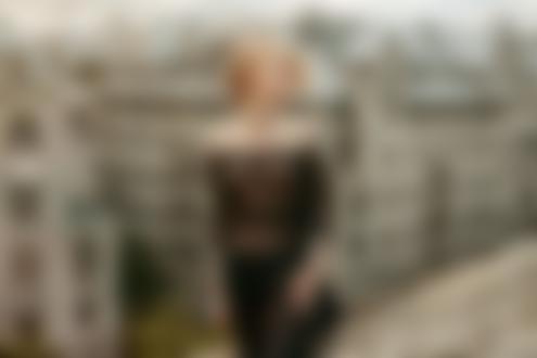 Обои для рабочего стола Модель Лина в прозрачной черной блузке и в джинсаж позирует, стоя на крыше здания с видом на городские дома, фотограф Игорь Куприянов