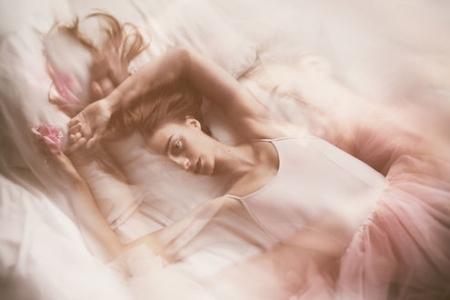 Обои на рабочий стол Модель Natalia Wolska с розовой розой в руке лежит на постели. фотограф Dorota Gorecka