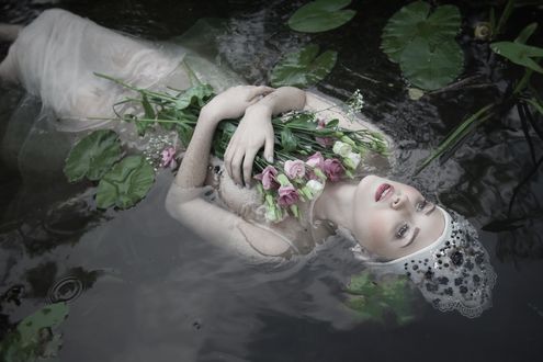 Обои на рабочий стол Модель Patrycja Iwanska с цветами в руке лежит в воде. фотограф Dorota Gorecka