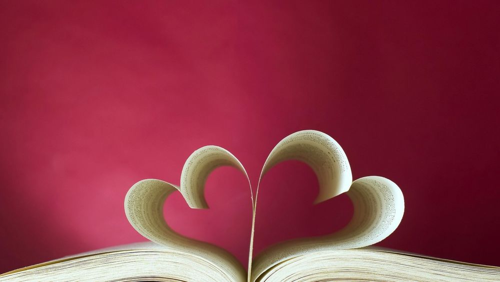 Обои для рабочего стола Раскрытая книга, листы которой сложены в два сердечка