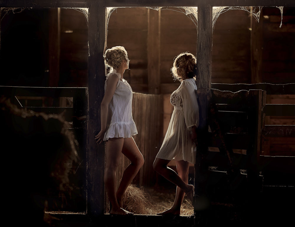 Обои для рабочего стола Две девушки в белых платьях стоят в конюшне, фотограф Ragan Sylwia