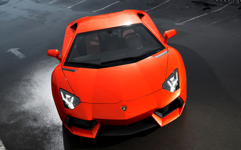 Обои для рабочего стола Ярко-оранжевый Lamborghini Aventador на темно-сером фоне