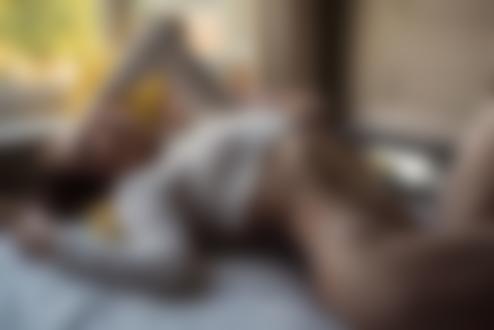 Обои на рабочий стол Стройная девушка в белой кофточке и в стрингах лежит на кровати в комнате, фотограф Jack Russell