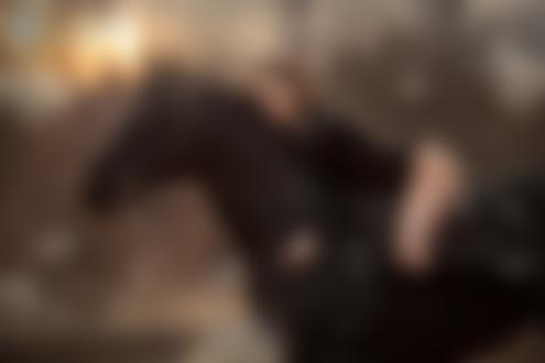 Обои на рабочий стол Девушка в черной кофте сидит на лошади под падающими белыми перьями, фотограф Анюта Онтикова