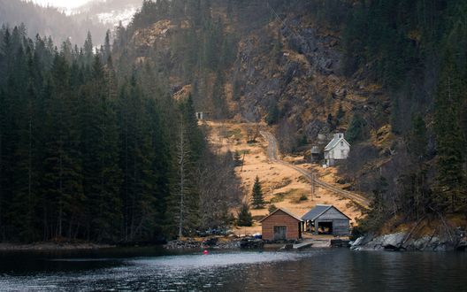 Обои на рабочий стол Домик с гаражом для лодки на берегу лесного озера, фотограф Lachlan Gowen