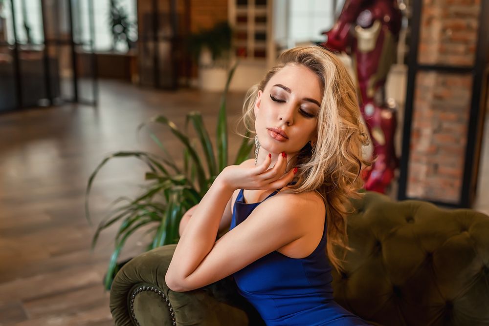 Блондинка на красном кожаном диване