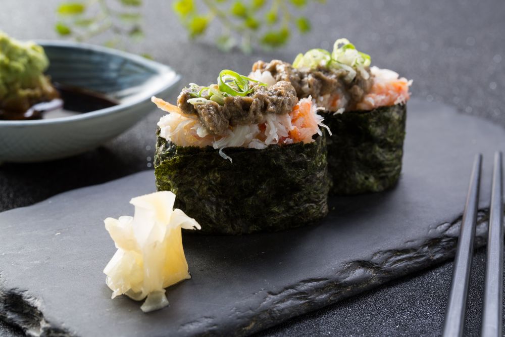 Обои для рабочего стола Японская кухня: роллы из морепродуктов рядом палочки для еды и имбирь