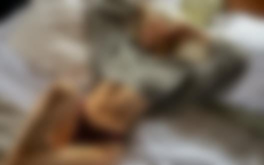 Обои на рабочий стол Девушка - блондинка в трусиках и приподнятом свитере лежит на постели