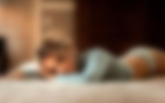 Обои для рабочего стола Симпатичная блондинка Mirthe в кофточке и в трусиках лежит на кровати в комнате и смотрит в камеру, фотограф Maarten Quaadvliet