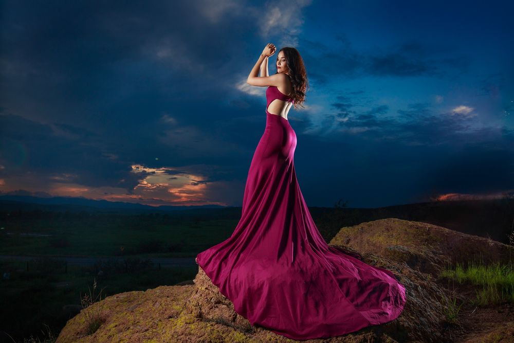 Обои для рабочего стола Модель Carolina Arras в бордовом вечернем платье позирует, стоя на выступе горного образования под вечерним небом, фотограф Alex Mendoza