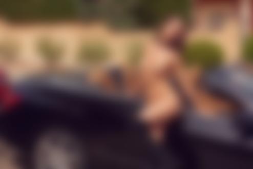 Обои на рабочий стол Обнаженная модель Вероника Климович в ботфортах стоит у авто