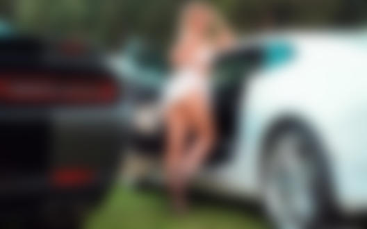 Обои на рабочий стол Девушка, приподняв платье, стоит у белого авто Chevrolet Camaro, фотограф Дмитрий Филатов
