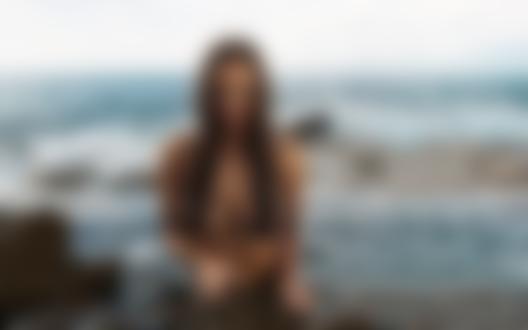 Обои для рабочего стола Модель Viki Odintcova топлес стоит на на каменистом берегу моря