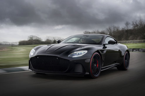 Обои на рабочий стол Мужчина едет по трассе за рулем черного Aston Martin DBS Superleggera в спецверсии от TAG Heuer