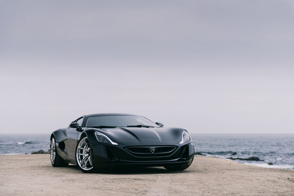 Обои для рабочего стола Черный спортивный электромобиль Rimac Concept One стоит на берегу моря