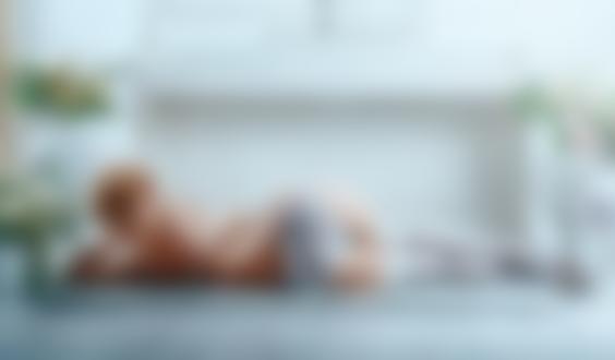 Обои для рабочего стола Блондинка в белом нижнем белье лежит на напольном коврике спиной к камере на фоне пианино и ваз с цветами в комнате, фотограф Сергей Рехов