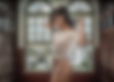 Обои на рабочий стол Девушка азиатской внешности стоит на фоне окна