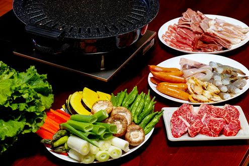 Обои на рабочий стол Японская кухня: ассорти из мяса, морепродуктов, овощей и зелени на тарелках и конфорка