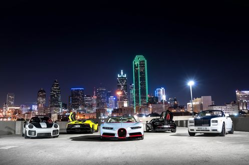 Обои на рабочий стол Авто Porsche 911 GT3, Lamborghini Aventador, Bugatti Chiron, McLaren 570S и Rolls-Royce Ghost стоят на площадке на фоне ночного города, фотограф Evan Sabin