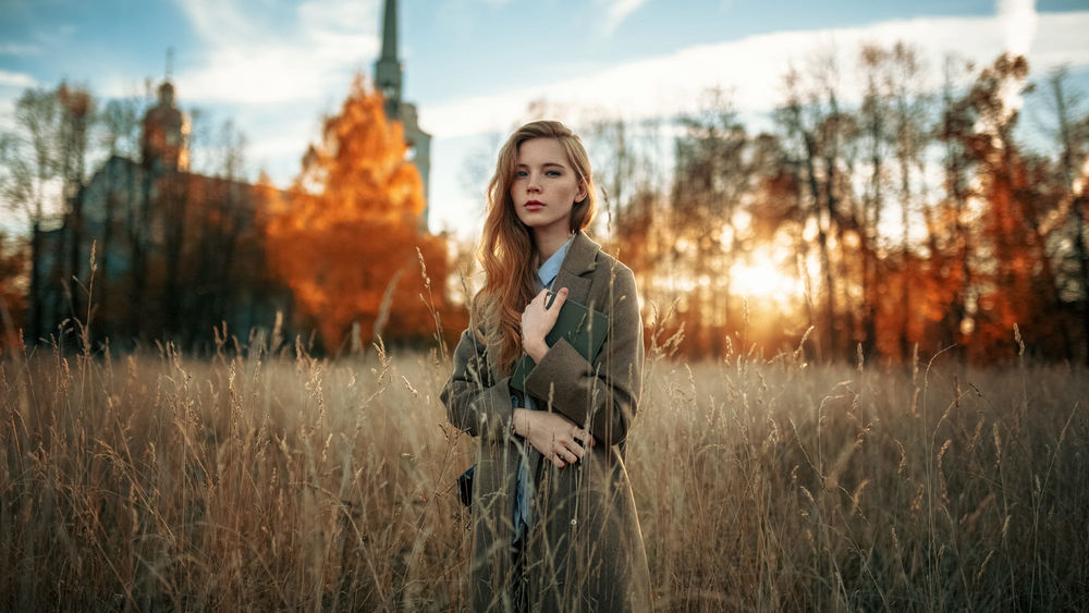 Обои для рабочего стола Девушка в пальто стоит среди высокой травы, фотограф Александр Куренной
