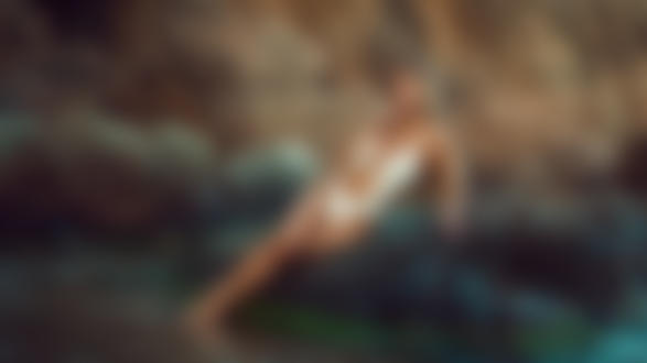 Обои на рабочий стол Блондинка Ariadna в белом купальнике на камне у воды, фотограф David Mas