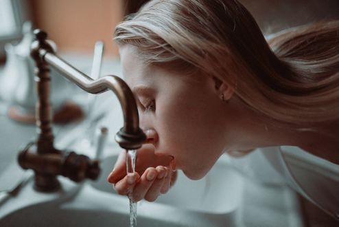 Обои на рабочий стол Девушка пьет воду из под крана. Фотограф Ульяна Найденкова