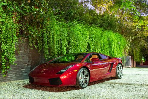 Обои на рабочий стол Красный Lamborghini Gallardo припаркован у кирпичного забора, покрытого зеленью