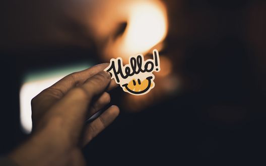 Обои на рабочий стол Рука держит cмайлик с надписью Hello! / Привет!