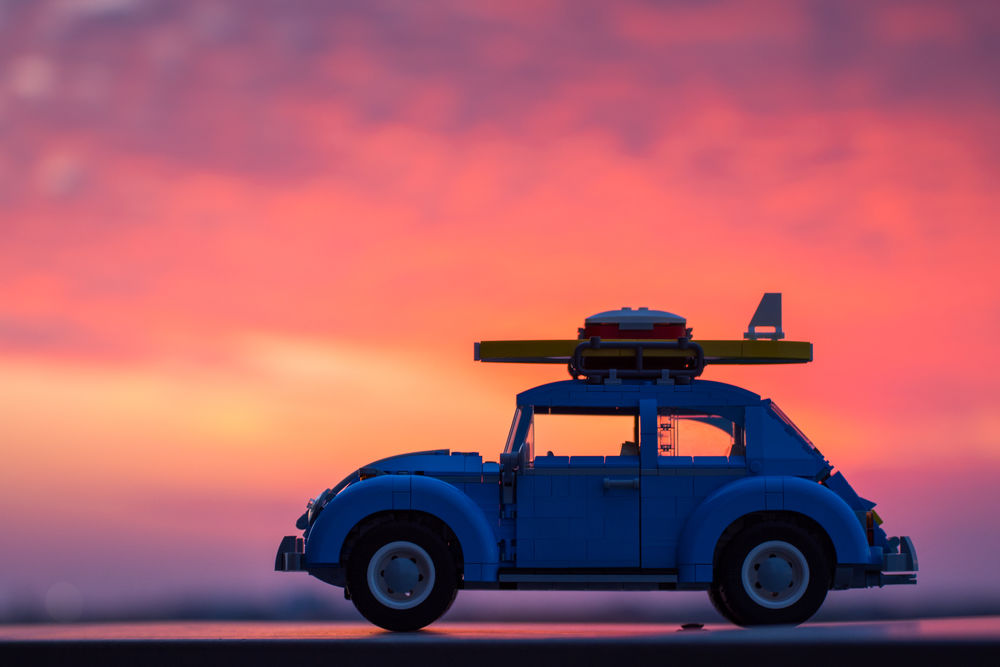 Обои для рабочего стола Авто Volkswagen Beetle на фоне облачного неба во время заката