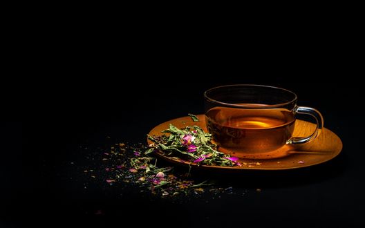 Обои на рабочий стол Чашка чая и цветочки на блюдце на черном фоне