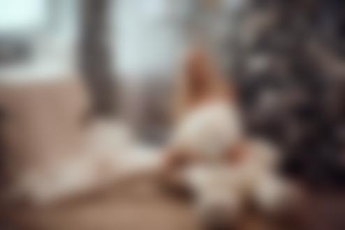 Обои на рабочий стол Девушка - блондинка с игрушечным мишкой сидит на полу у елки