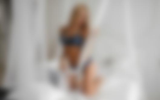 Обои на рабочий стол Блондинка в голубом нижнем белье стоит на коленях на кровати в спальной комнате