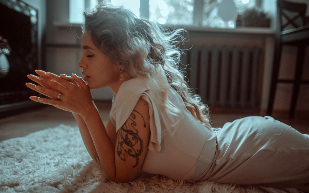 Обои для рабочего стола Девушка лежит на ковре на полу. Фотограф Juliana Naidenova