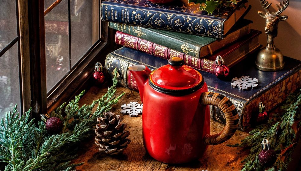 Обои для рабочего стола Красный чайник, шишки, книги, еловые ветки и новогодние украшения на подоконнике