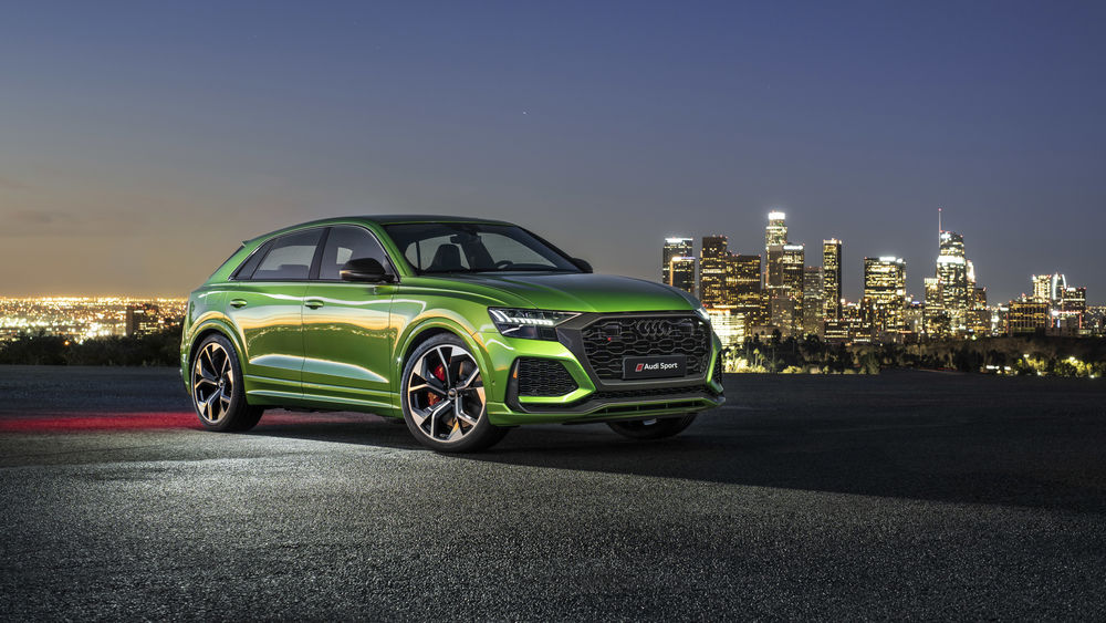 Обои для рабочего стола Зеленый Audi RS Q8 2020 стоит на фоне вечернего города