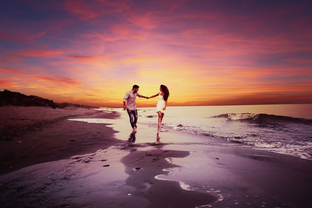 Молодой мужчина и молодая девушка обнимаются на берегу моря на закате foto de Stock | Adobe Stock